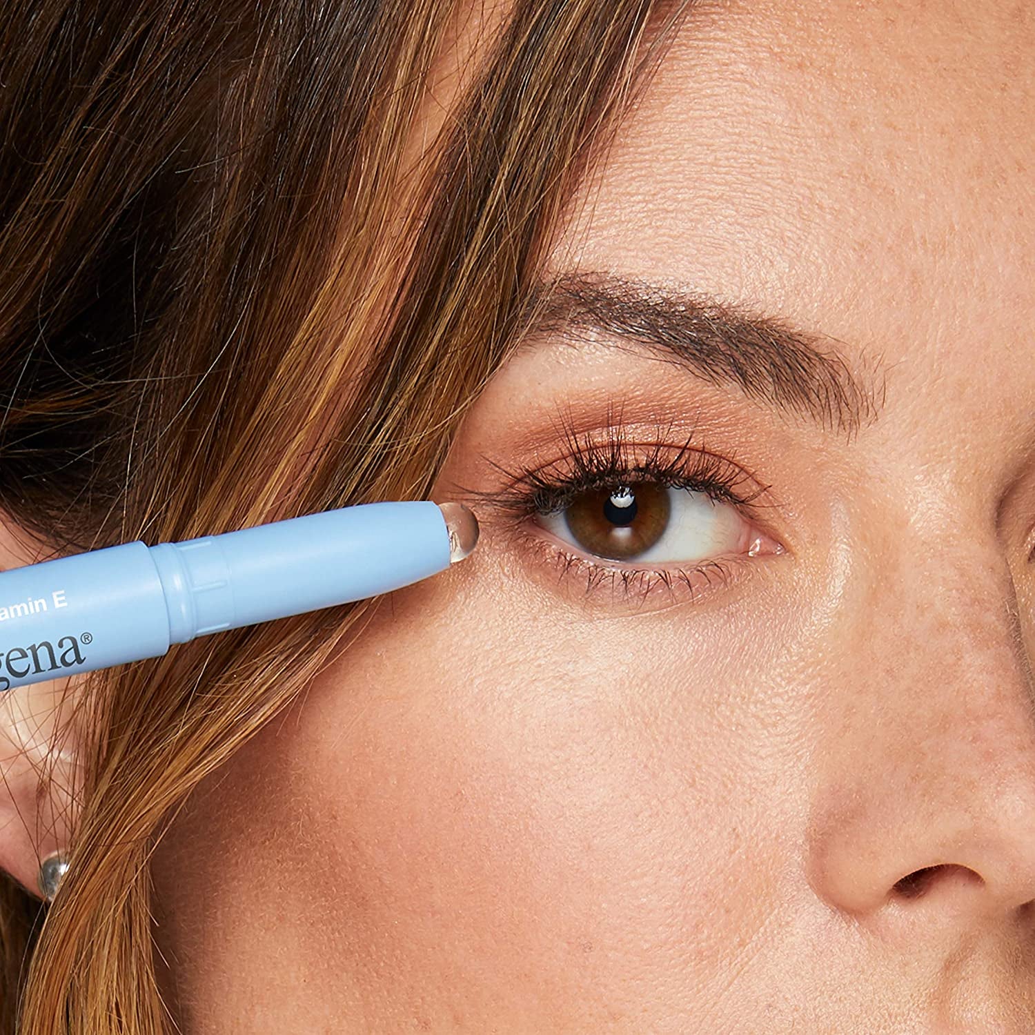 the makeup eraser stick held to a model's eye