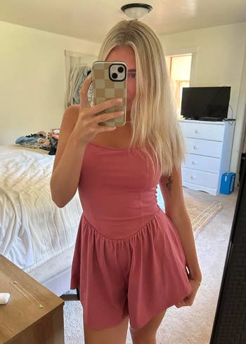 Person successful  a sleeveless, casual formal  takes a reflector  selfie successful  a chamber  with a phone