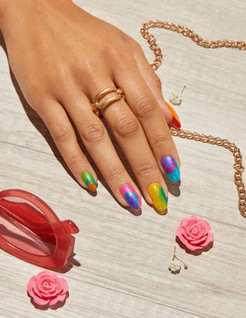 model hand with various colors of polishes from the set