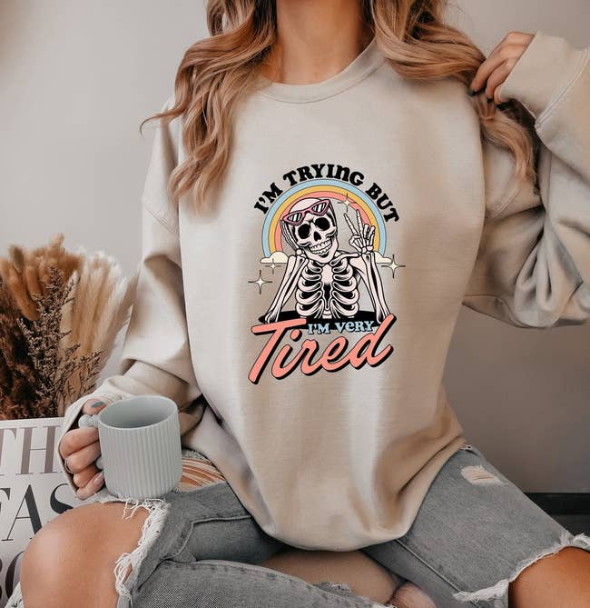Person in a sweatshirt with a skeleton graphic and text 