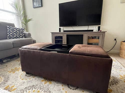reviewer photo of brown faux leather ottoman with reversible tray cushions
