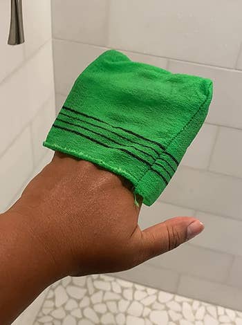 A reviewer holding an exfoliating bath washcloth in green