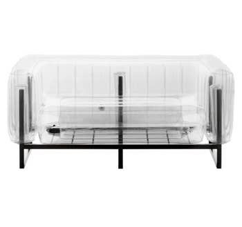 Transparent inflatable couch with black metal foundation on a white background