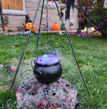 reviewer's cauldron with lights and smoke coming out. used as outdoor decor with tripod holding it over faux coals. 