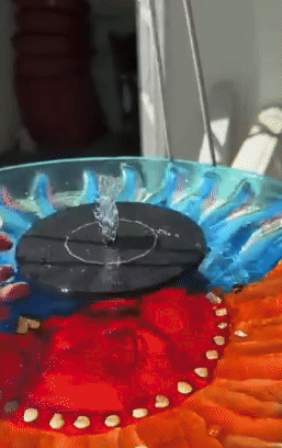 Colorful decorative solar-powered h2o  fountain operating outdoors