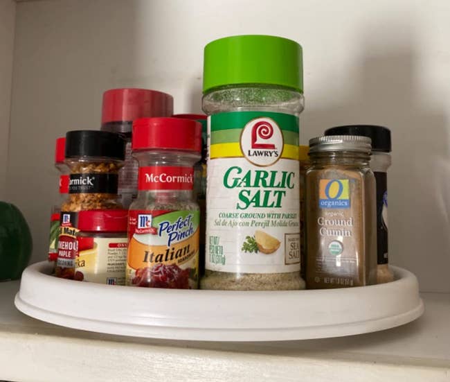reviewer photo of the lazy susan inside a cabinet holding various spices