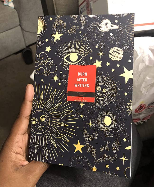 A reviewer holding a copy of the journal with celestial patterns on it