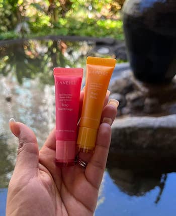 reviewer holding two Laneige lip balms