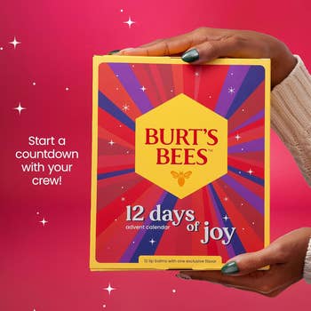 Hands holding Burt's Bees advent calendar box, with substance   