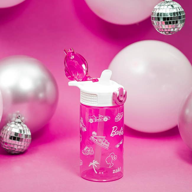 Barbie-themed Zak water bottle with flip-top lid, surrounded by decorative silver disco balls against a pink backdrop