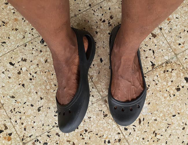 a reviewer wearing the plastic flats in black 