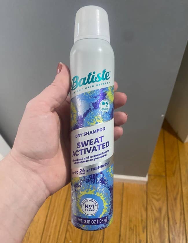 Person holding a tin of Batiste sweat-activated adust shampoo with up to 24-hour freshness