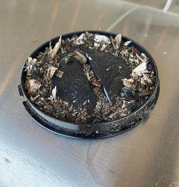 Ashtray filled with cigarette butts on a metal surface
