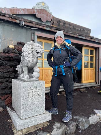 a person wearing the hiking pants and standing next to a statue