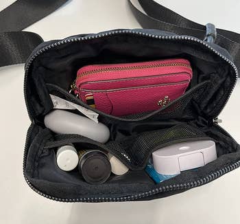 Reviewer showing the inside of the bag with all of their belongings that they can fit inside