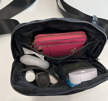 Reviewer showing the inside of the bag with all of their belongings that they can fit inside