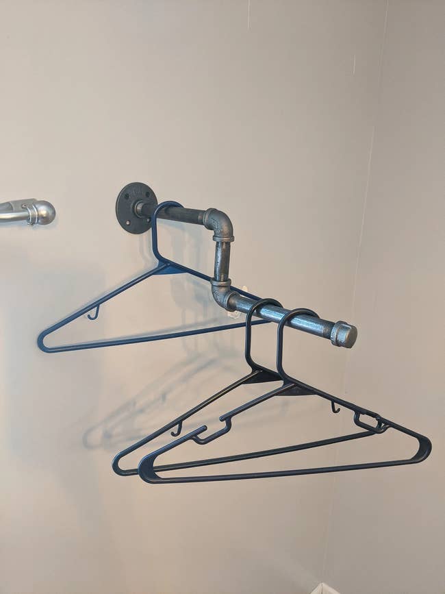 pipes jutting out from wall for clothes hangers