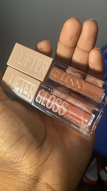 reviewer holding two lip glosses