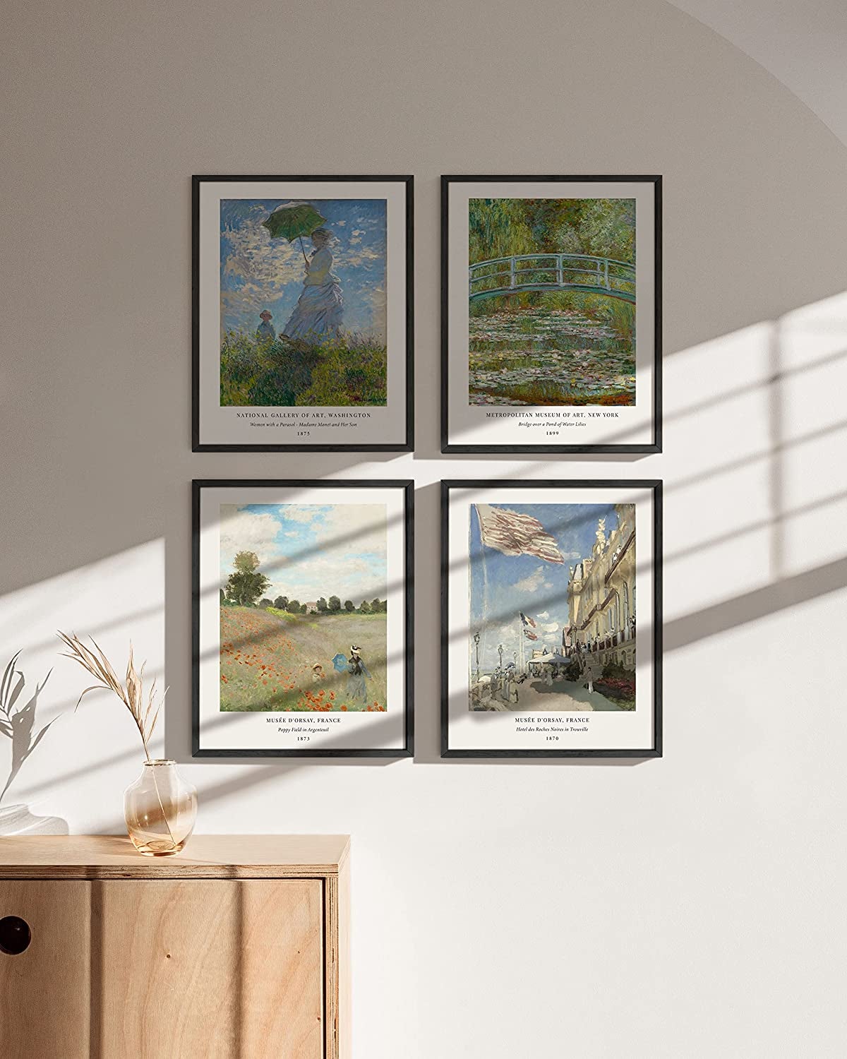 a set of four posters depicting monet art framed on a white wall 