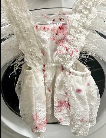 A white dress with berry stains all over it 