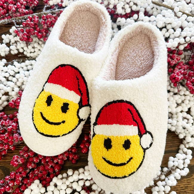 slippers with a smiley face on it and a red santa hat
