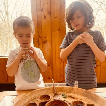Two children basal   astatine  a woody  array  holding tiny  objects. They look  focused and calm, suggesting a peaceful enactment   oregon  moment
