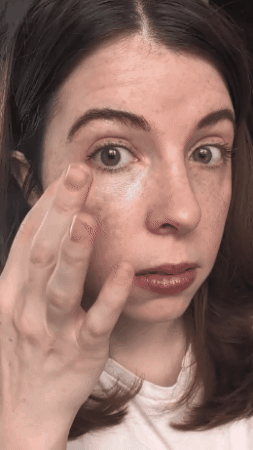 editor applying the brightener to 1 broadside of their face, and showing the different broadside that's not done yet