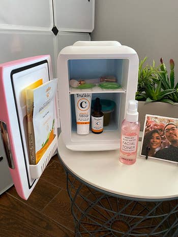 a reviewer's pink beauty fridge filled with skincare products