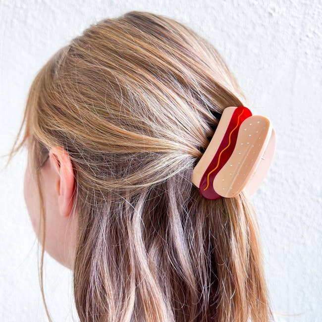 Hair clip shaped like a sandwich worn in a person's hair. It's a quirky accessory for a unique fashion statement