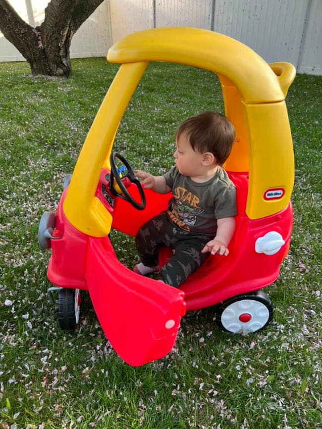 Toddler in a little tikes cozy coupe car