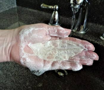 Someone holding the leaf soap in a sink