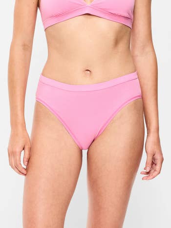 Person modeling pinkish underwear acceptable against a plain background