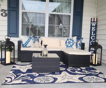 foto pengulas teras dengan furnitur di atas karpet biru tua dan cokelat bermotif bintang laut