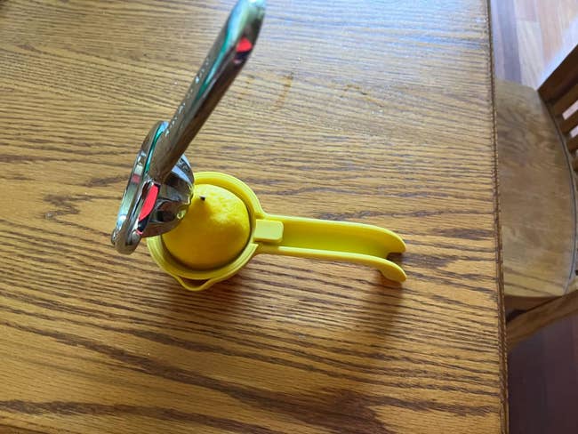 Lemon squeezer with a citrus  wrong  connected  a woody  table, highlighting a room  instrumentality   for casual  foodstuff  extraction