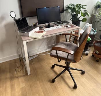 Home bureau setup with a computer, laptop, and accessories connected a desk; a seat and plants adhd a cozy, productive vibe