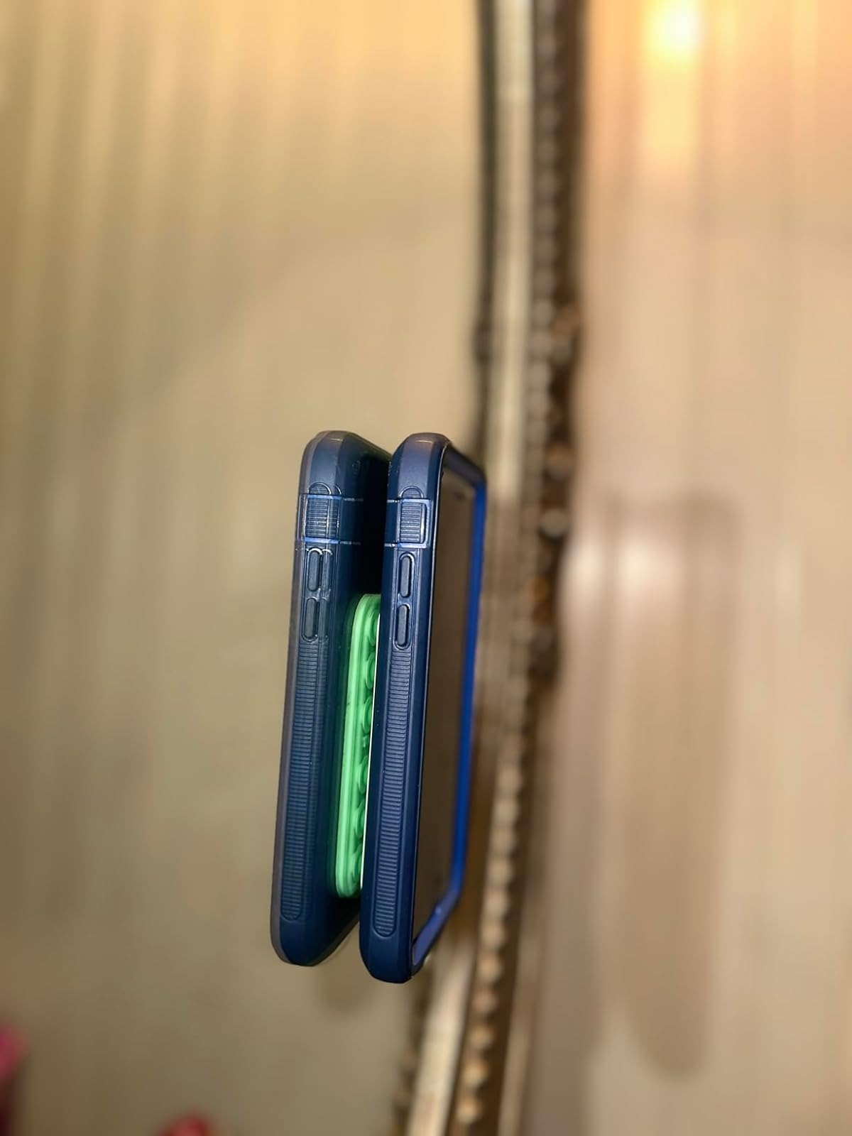 Two smartphones with protective cases, viewed from the side, showing their thickness and button placements