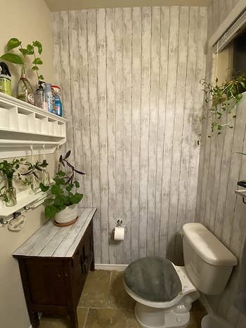reviewer photo of the shiplap wallpaper in their bathroom
