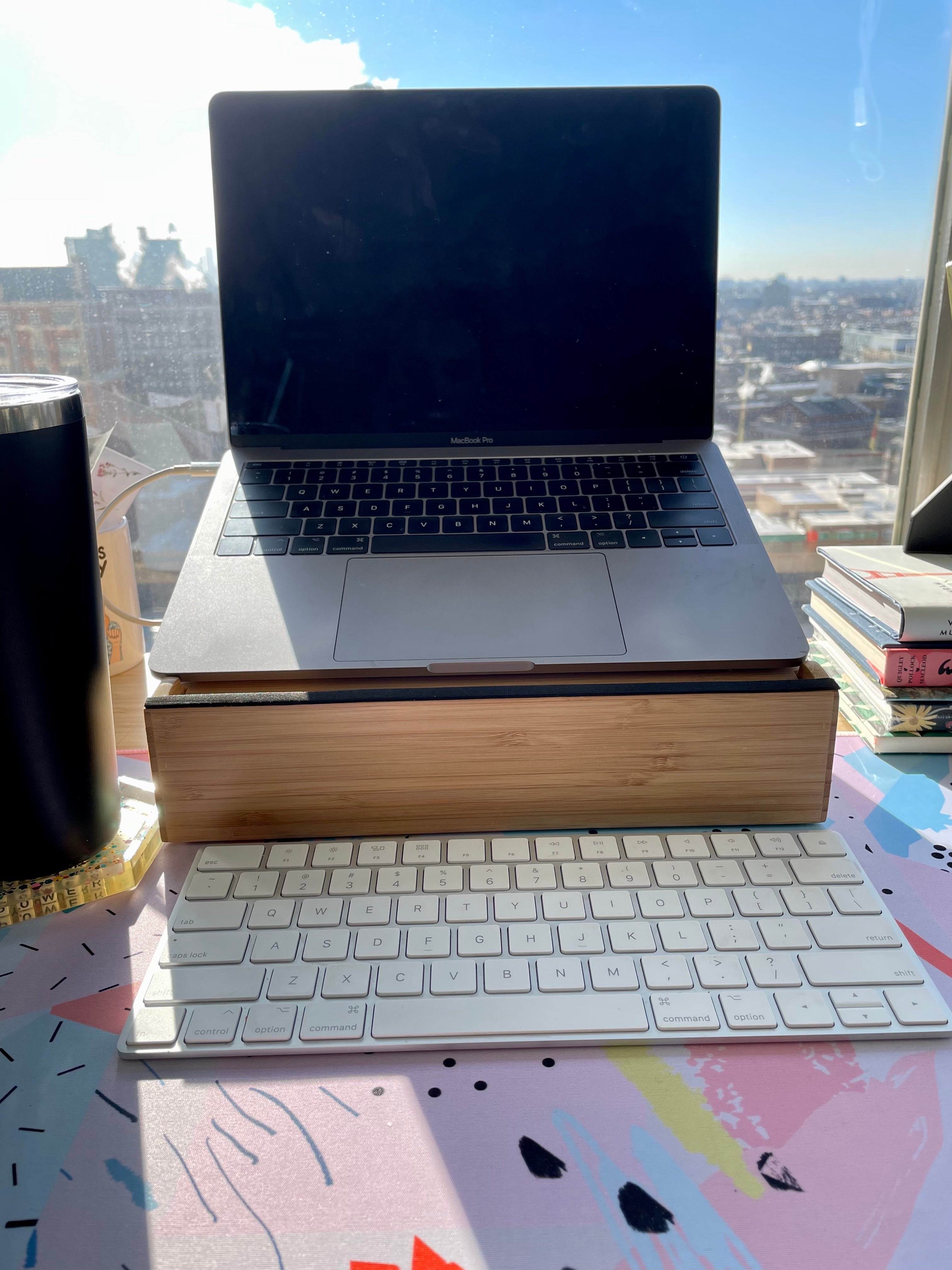 the bamboo laptop stand on a desk with a laptop on it