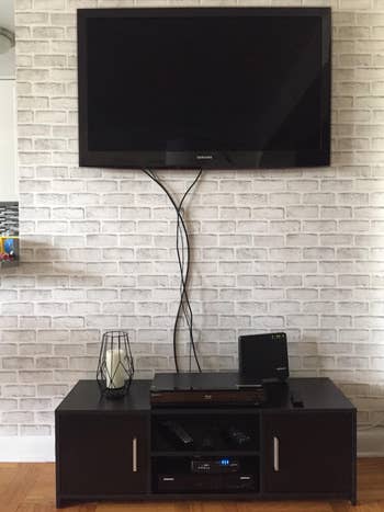 before of a reviewer's TV with black cables hanging down