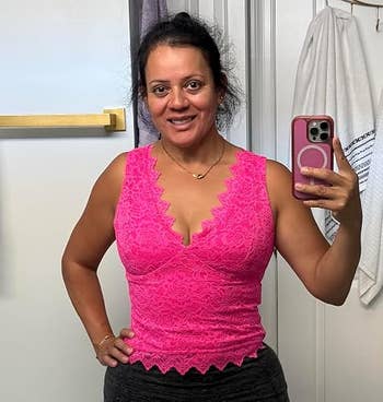 Person successful a pinkish lace sleeveless apical takes a selfie successful a bathroom