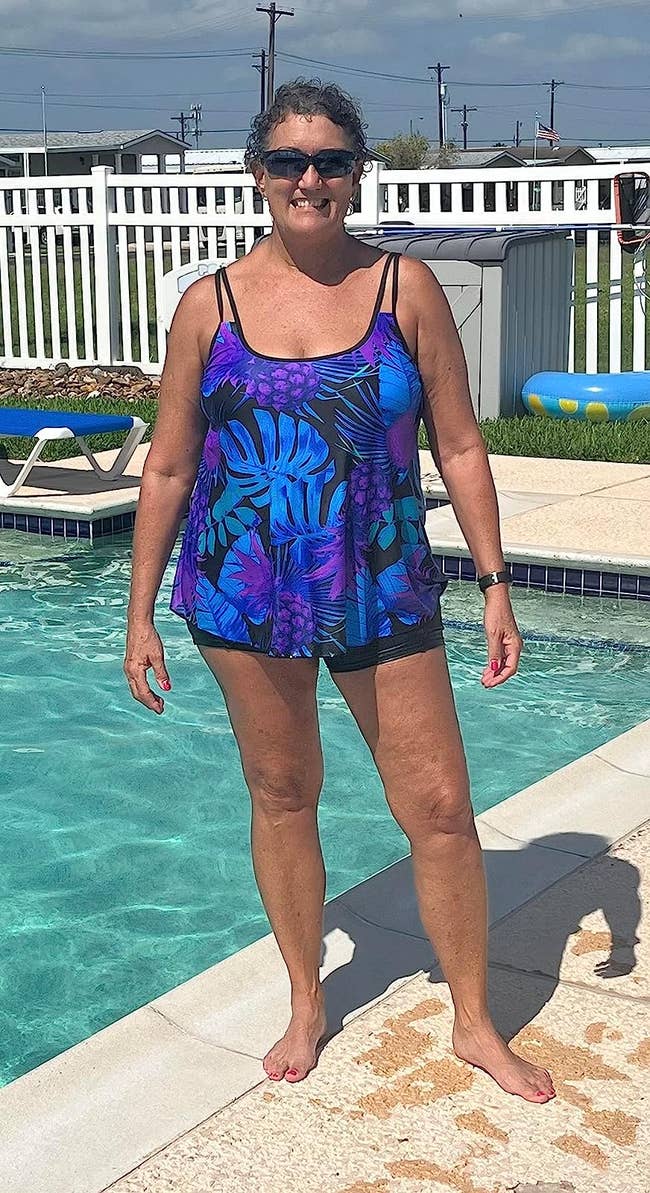 reviewer posing in colorful tankini by a pool