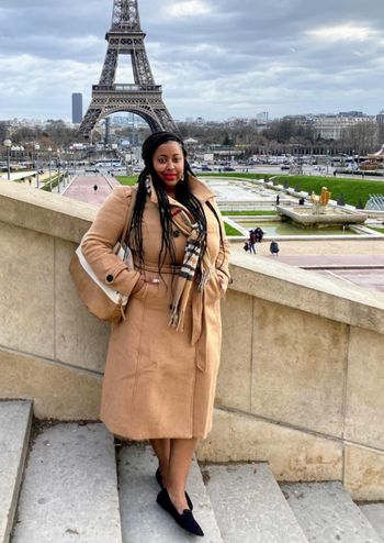 reviewer wearing the tan coat in front of Eiffel Tower