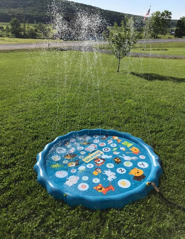 a reviewer's mini splash pad with water spraying out of it