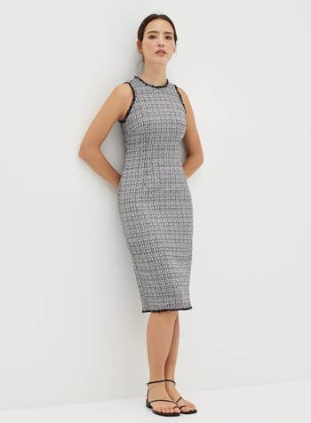 model wearing black and white tweed bodycon dress with strappy sandals