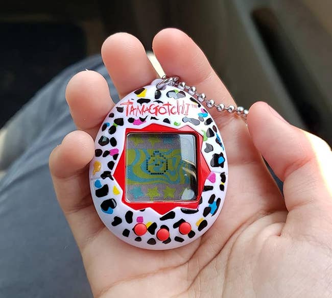reviewers colorful Tamagotchi toy with virtual pet on the screen