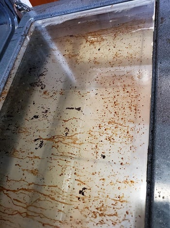 Glass oven door with brown dripping stains on it