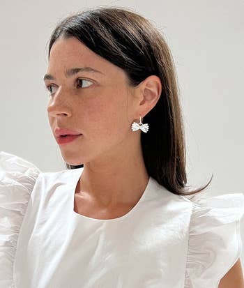 a model wearing the silver earrings
