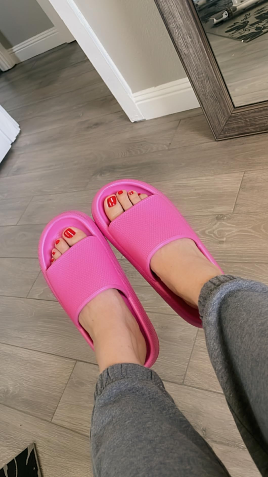 Person wearing pinkish  descent  sandals and grey  sweatpants