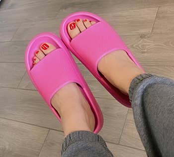 Person wearing pinkish descent sandals and grey sweatpants