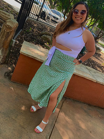 a reviewer wearing the skirt in light green with a white dotted print 